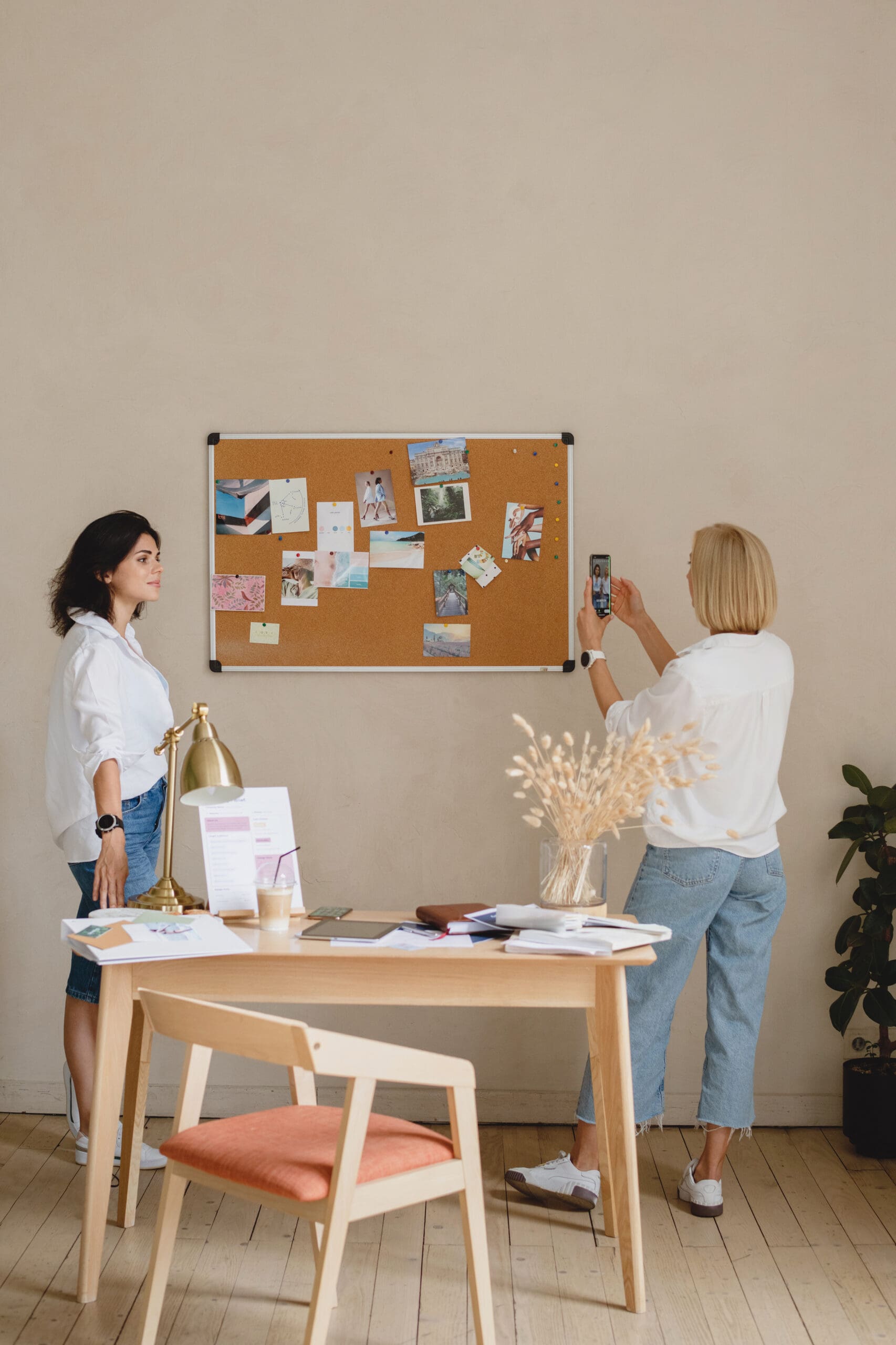Two service business women planning operational systems together in a professional workspace