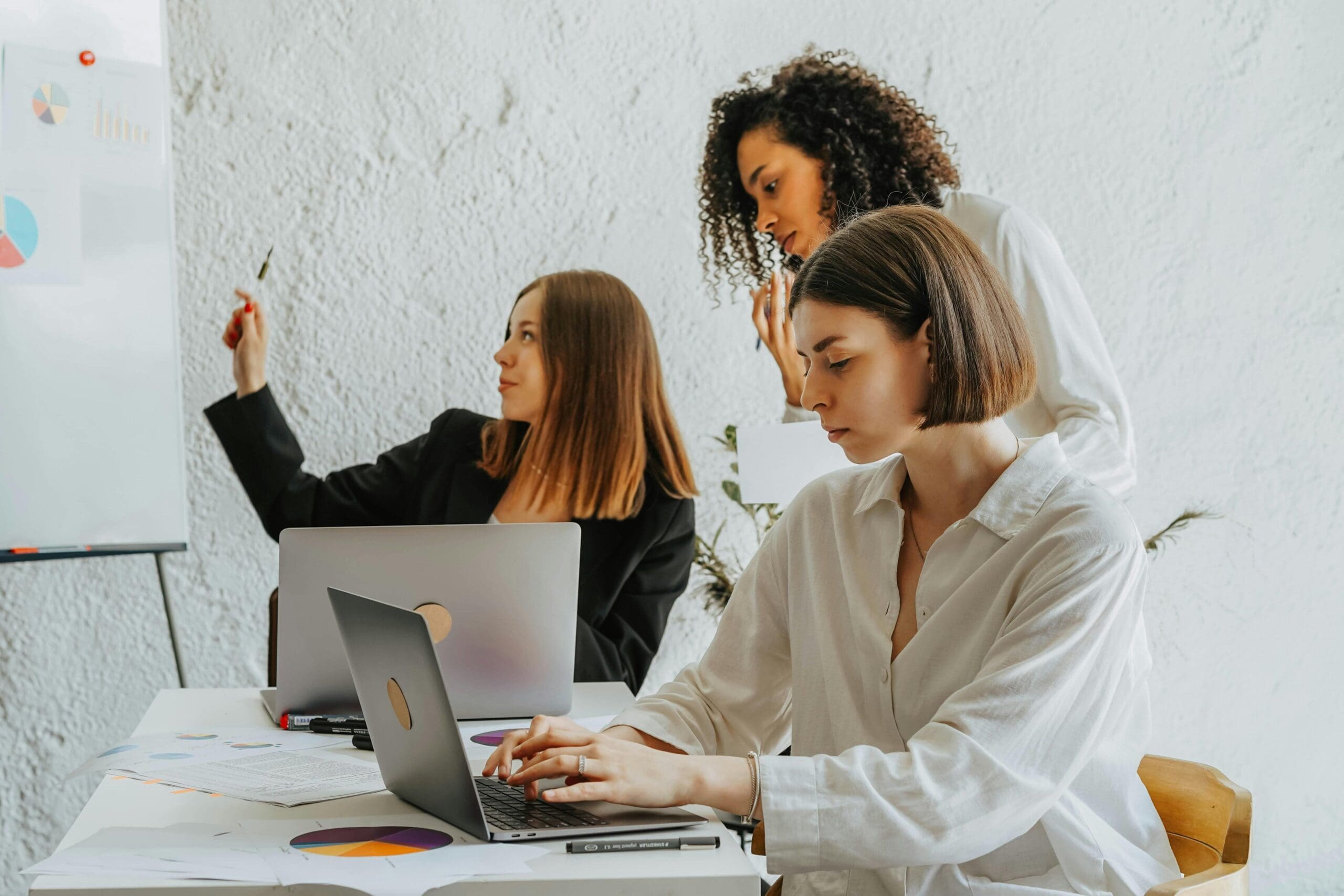 Small service business team working together at a desk with laptops and documents